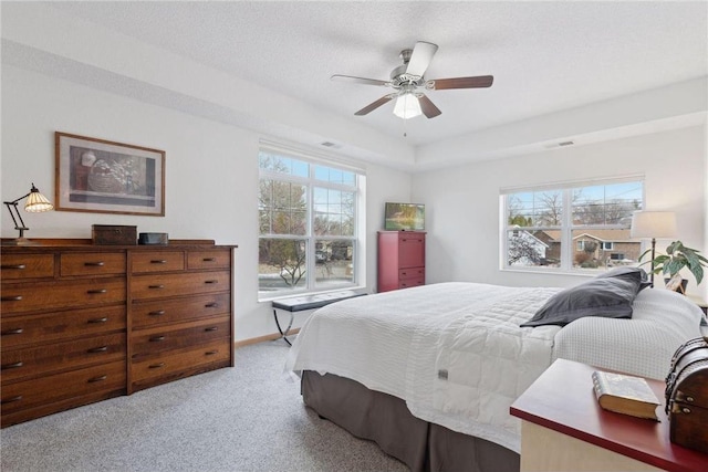 carpeted bedroom with ceiling fan and a textured ceiling