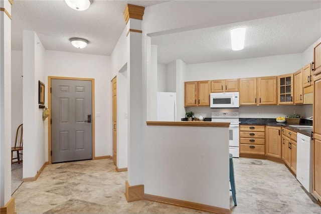 kitchen featuring light brown cabinets, a textured ceiling, white appliances, and kitchen peninsula