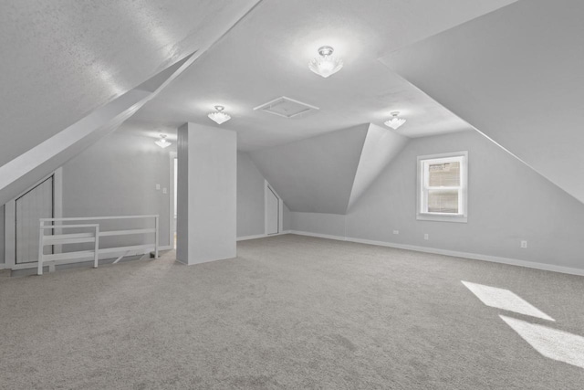 bonus room with vaulted ceiling and carpet