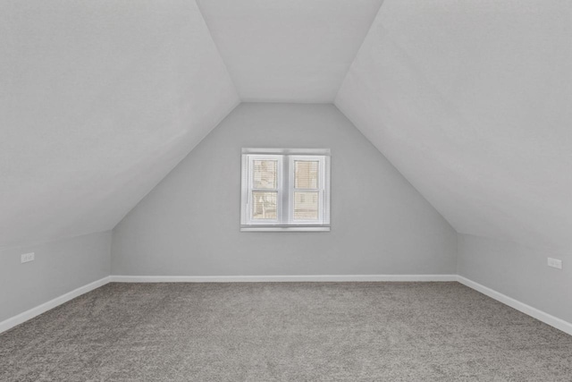 bonus room with lofted ceiling and carpet