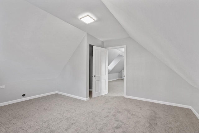 additional living space featuring lofted ceiling and carpet floors