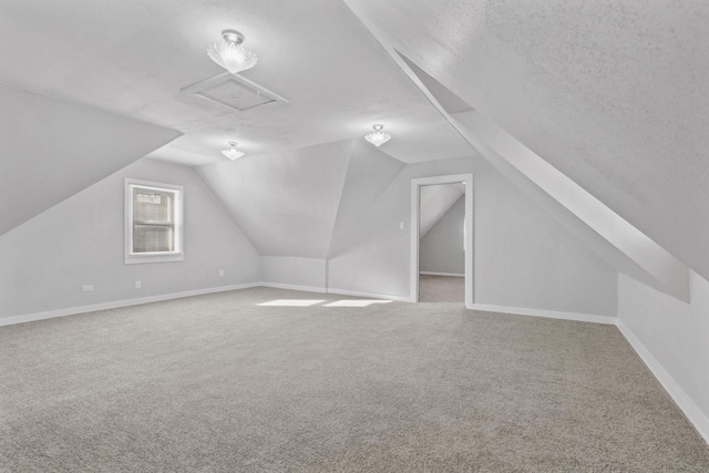 bonus room featuring lofted ceiling, carpet flooring, and a textured ceiling