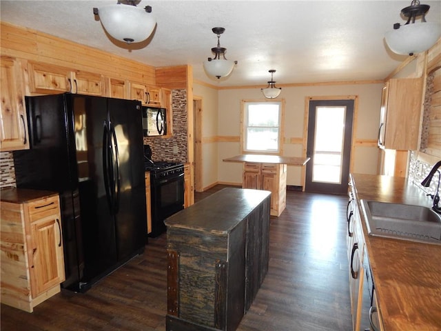 kitchen with sink, hanging light fixtures, backsplash, dark hardwood / wood-style floors, and black appliances