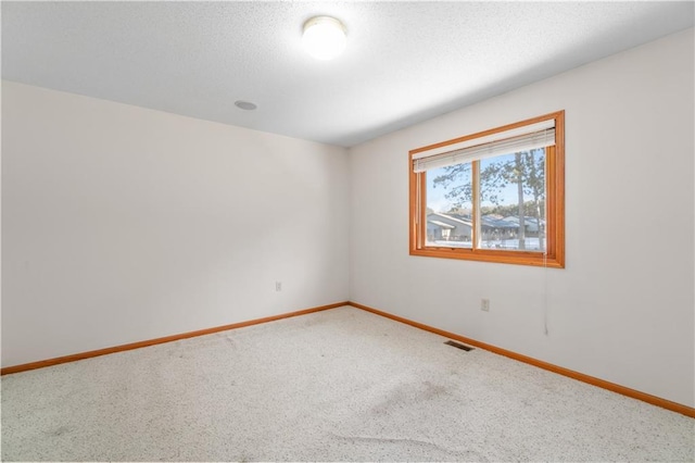 unfurnished room with carpet floors and a textured ceiling