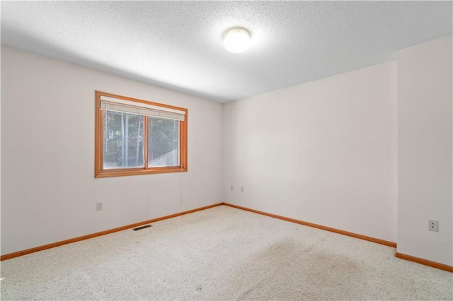 spare room with carpet floors and a textured ceiling