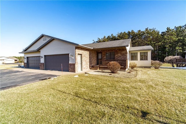 ranch-style home featuring a garage, a front lawn, and covered porch