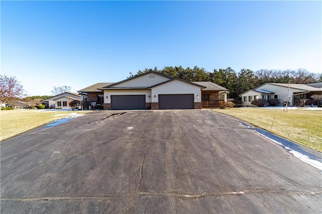 ranch-style home with a garage and a front lawn