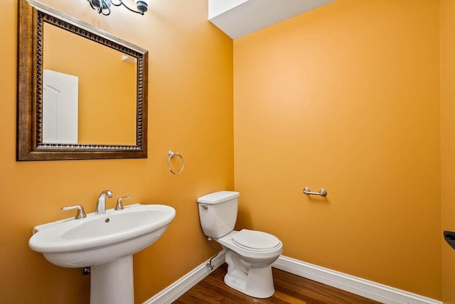 bathroom featuring wood-type flooring and toilet