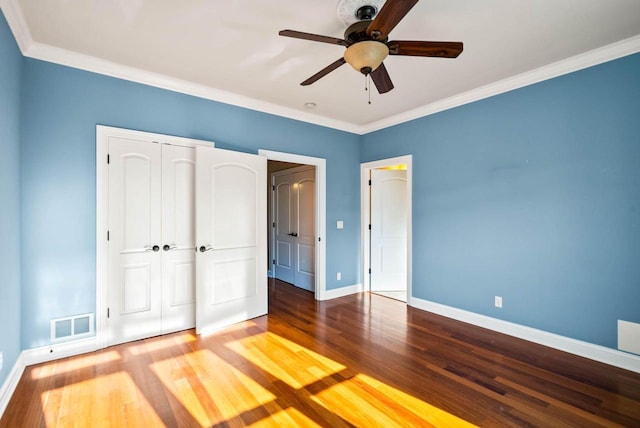 unfurnished bedroom with hardwood / wood-style flooring, ornamental molding, a closet, and ceiling fan