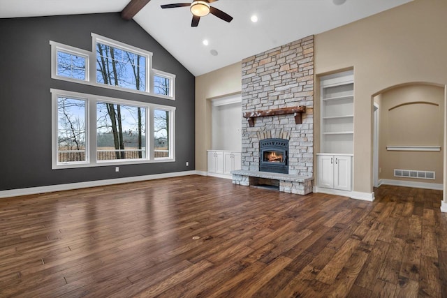 unfurnished living room with built in features, high vaulted ceiling, a fireplace, ceiling fan, and dark wood-type flooring