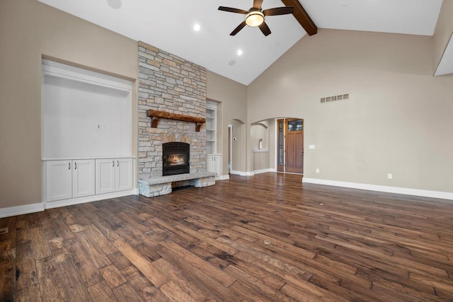 unfurnished living room with ceiling fan, dark wood-type flooring, a fireplace, and beamed ceiling