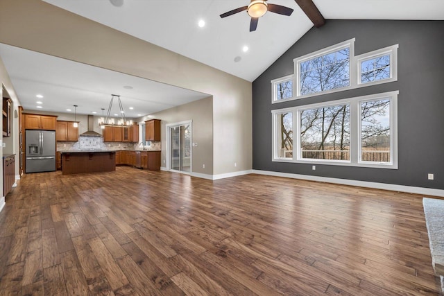 unfurnished living room with dark wood-type flooring, plenty of natural light, high vaulted ceiling, and beamed ceiling