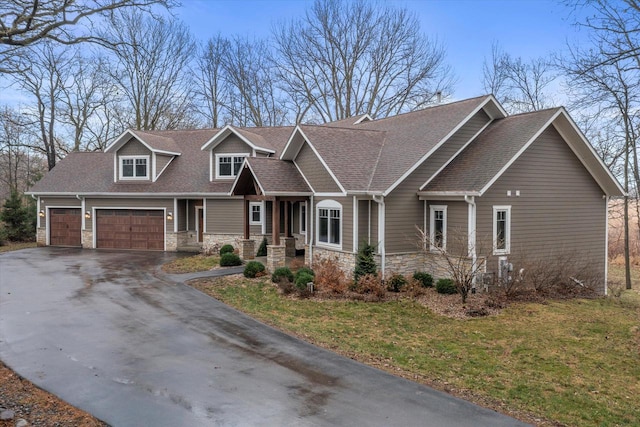 craftsman inspired home featuring a garage and a front yard