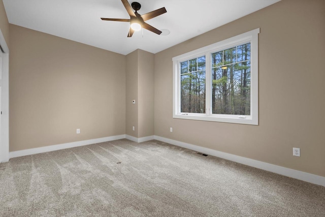 carpeted spare room featuring ceiling fan