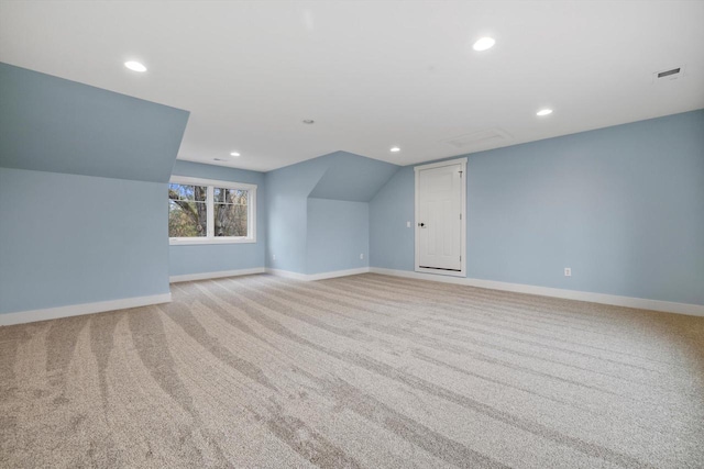 additional living space with light colored carpet and vaulted ceiling