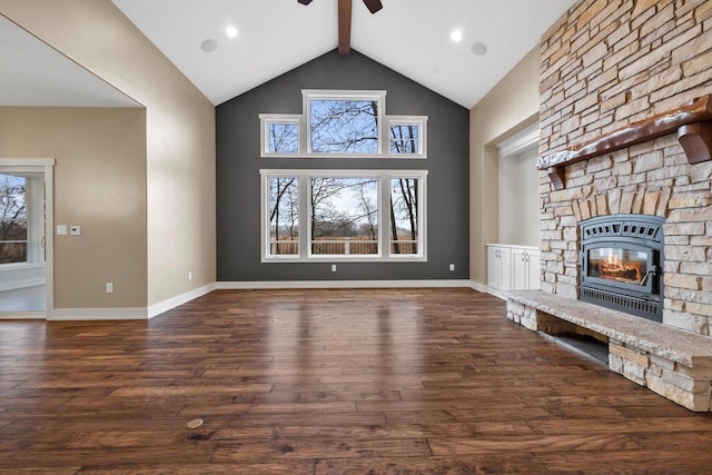 unfurnished living room with high vaulted ceiling, dark hardwood / wood-style floors, a stone fireplace, and beam ceiling