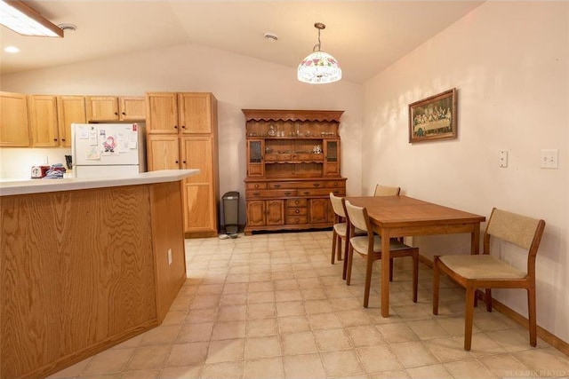 kitchen featuring hanging light fixtures, white fridge, and lofted ceiling