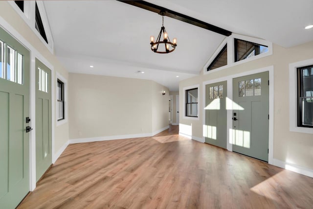 entrance foyer with high vaulted ceiling, beam ceiling, light hardwood / wood-style floors, and a notable chandelier