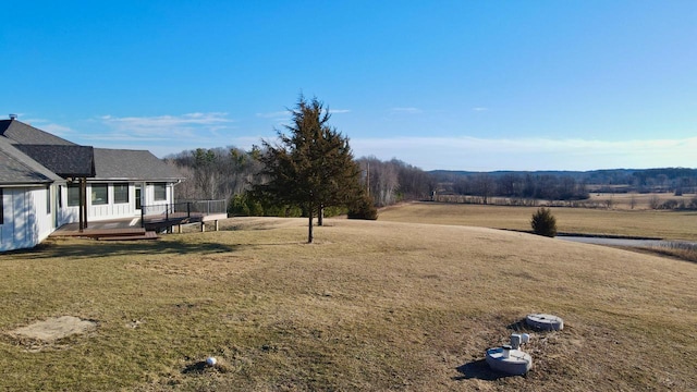 view of yard with a rural view and a wooden deck