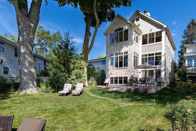 rear view of house featuring a lawn