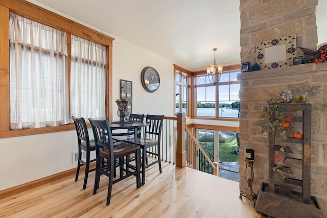 dining room with an inviting chandelier, light hardwood / wood-style floors, and a water view