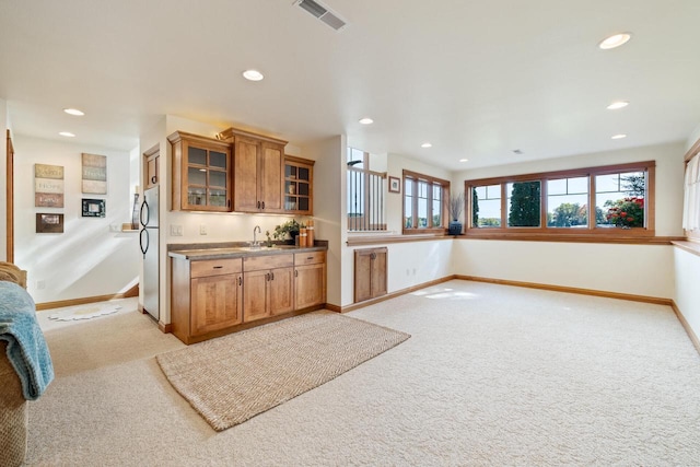 kitchen featuring light carpet, sink, and stainless steel fridge