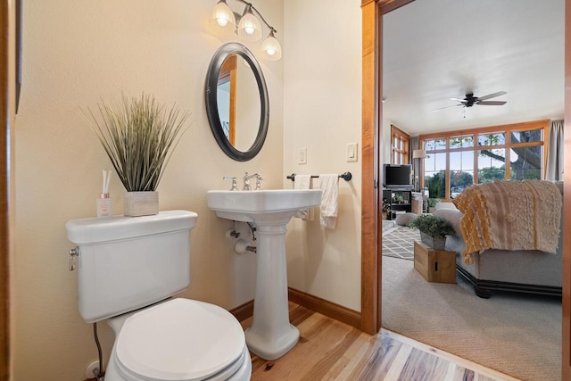 bathroom with hardwood / wood-style flooring, ceiling fan, and toilet