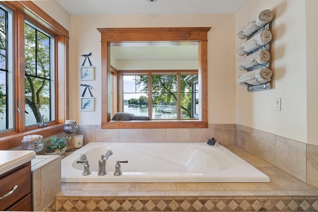 bathroom featuring a relaxing tiled tub and vanity