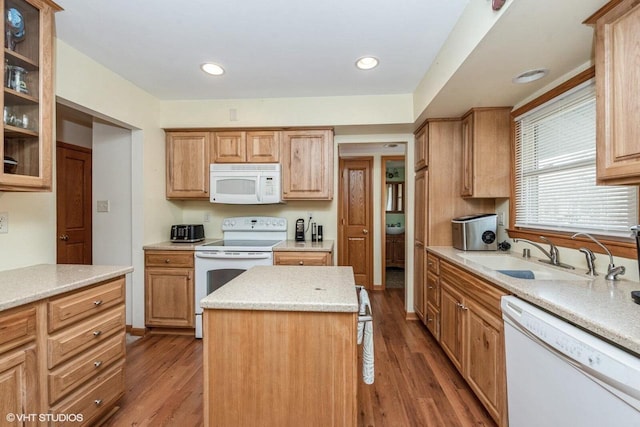 kitchen with a center island, sink, white appliances, and light hardwood / wood-style flooring