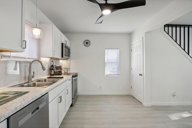 kitchen featuring decorative light fixtures, tasteful backsplash, white cabinetry, sink, and stainless steel appliances