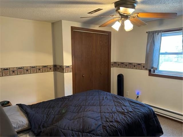 bedroom with visible vents, ceiling fan, baseboard heating, a textured ceiling, and a closet