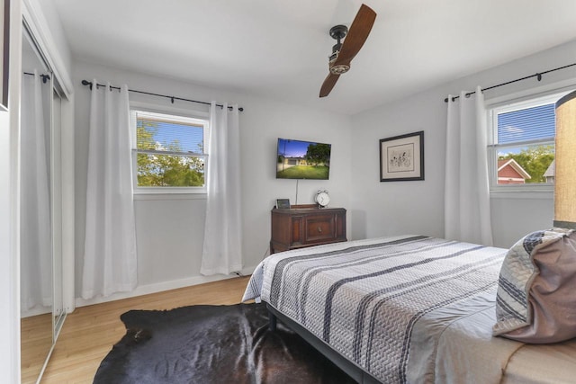 bedroom featuring multiple windows, ceiling fan, and light wood-type flooring