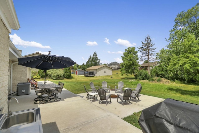 view of patio with area for grilling, sink, and a fire pit