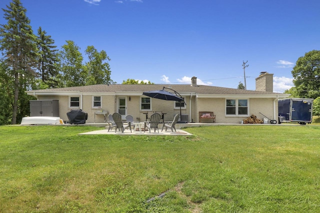 rear view of house featuring a yard and a patio