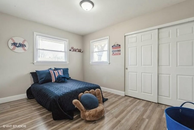 bedroom with light hardwood / wood-style floors and a closet