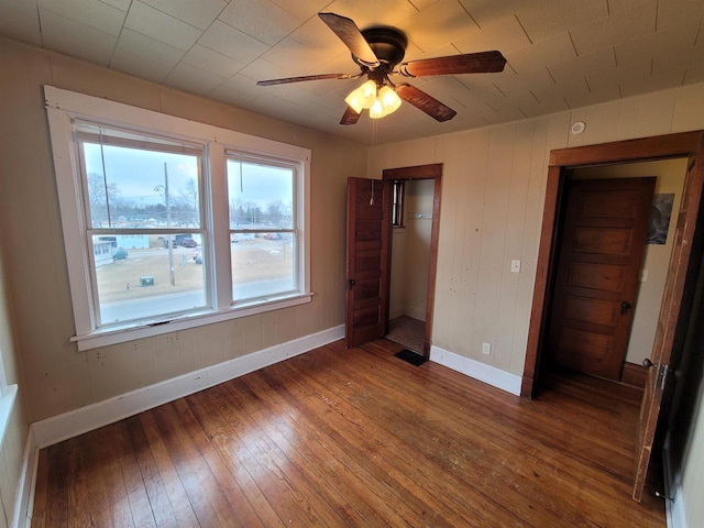 unfurnished bedroom featuring dark wood-type flooring and ceiling fan