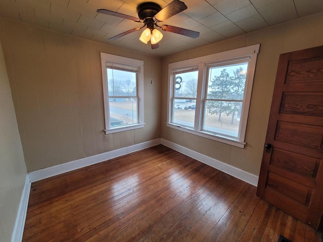 empty room with ceiling fan and dark hardwood / wood-style floors