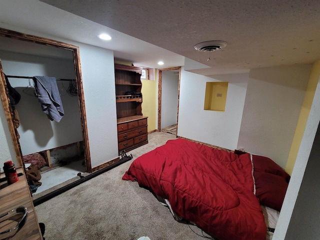 bedroom featuring light colored carpet and a textured ceiling