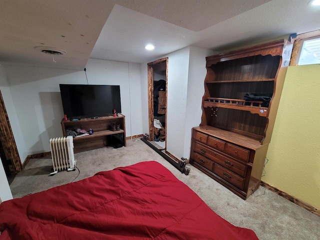 bedroom featuring radiator and light carpet