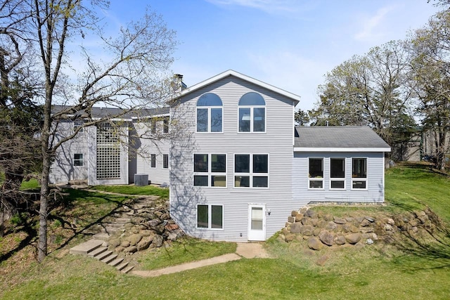 back of house featuring a yard and central air condition unit