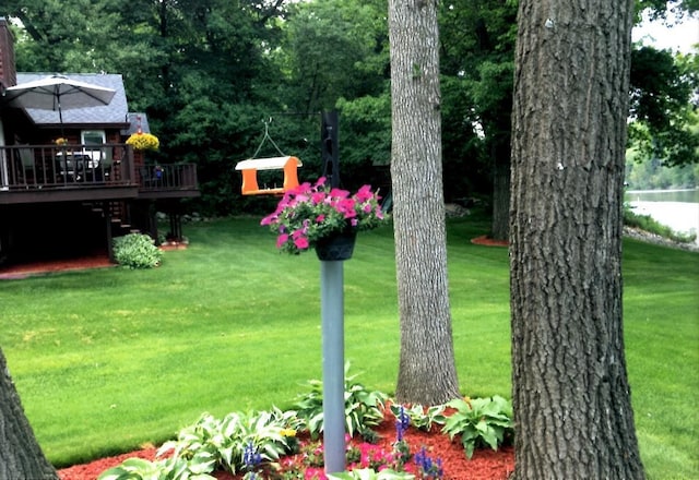 view of yard with a deck with water view