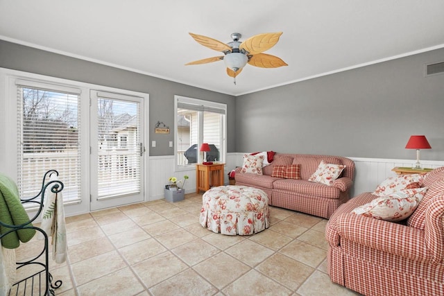 tiled living room with ornamental molding and ceiling fan