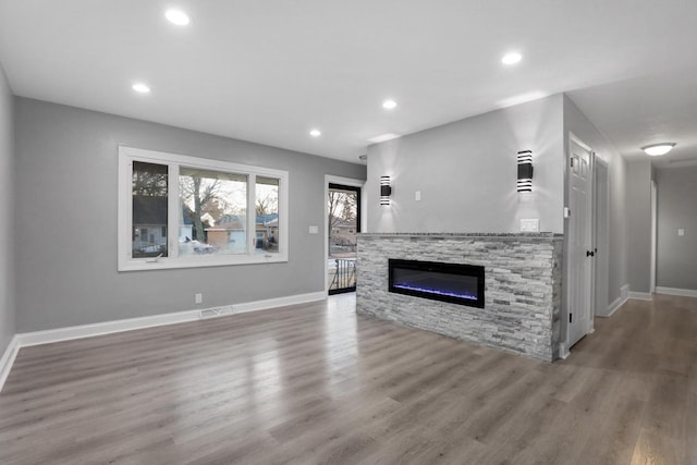 unfurnished living room featuring hardwood / wood-style flooring and a fireplace