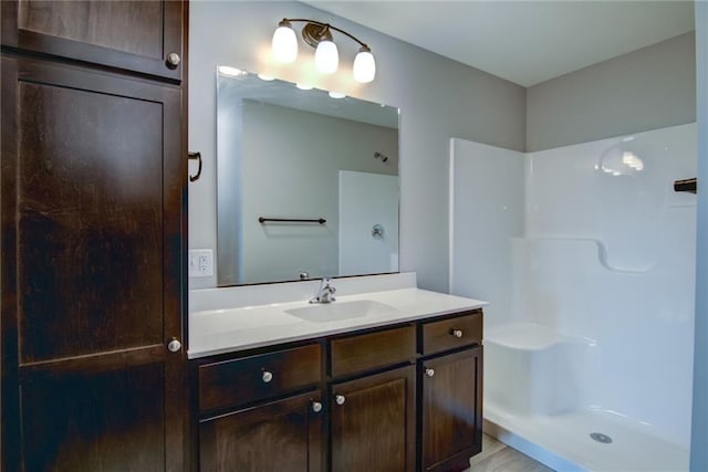 bathroom with walk in shower and vanity