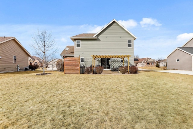 rear view of property with a pergola and a lawn