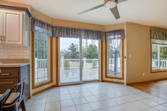 doorway featuring ceiling fan and light tile patterned floors