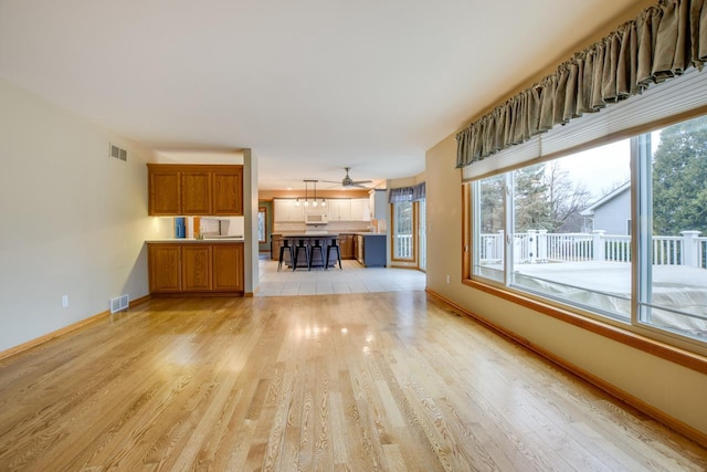 unfurnished living room with light hardwood / wood-style flooring and a wealth of natural light