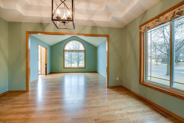 interior space featuring an inviting chandelier, light hardwood / wood-style flooring, and vaulted ceiling