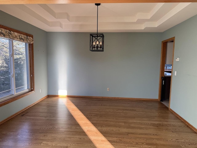 interior space featuring dark hardwood / wood-style floors, a notable chandelier, and a tray ceiling