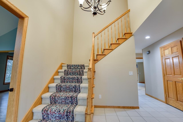 stairs with an inviting chandelier and tile patterned flooring